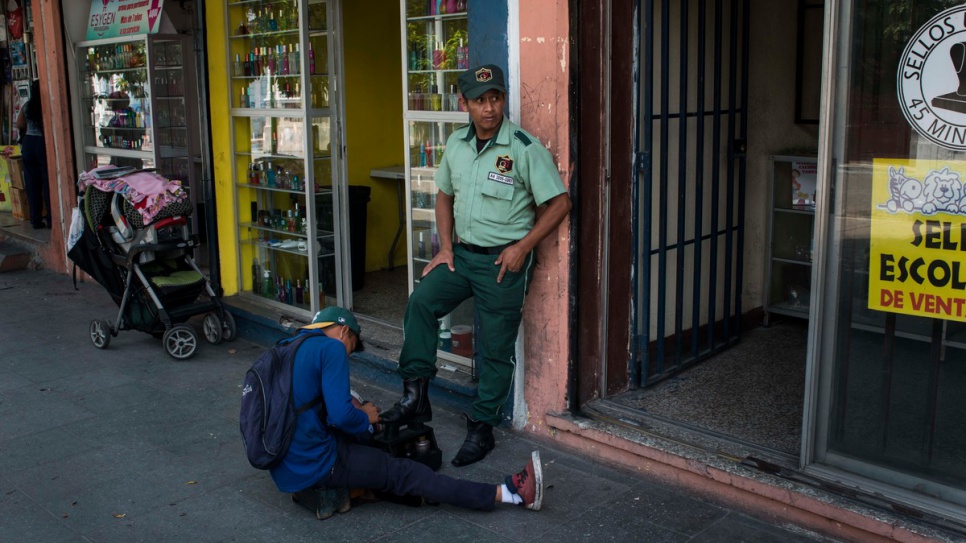 A private security guards gets his boots shined as he stands guard to a shop in downtown Guatemala City. Deteriorating security has created a boom for private security firms. According to one estimate, private security guards outnumber police officers in the country by almost four to one.