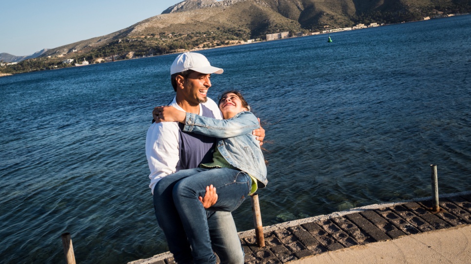 Bashar and Ensaf share a light moment by the sea, while waiting for their claim to reunite with family members to be processed in Greece.