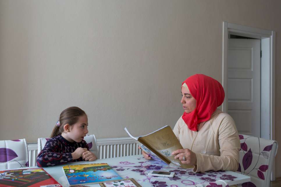 "I left Syria for the sake of my daughter," says Darie, who helps her daughter with her homework. 
