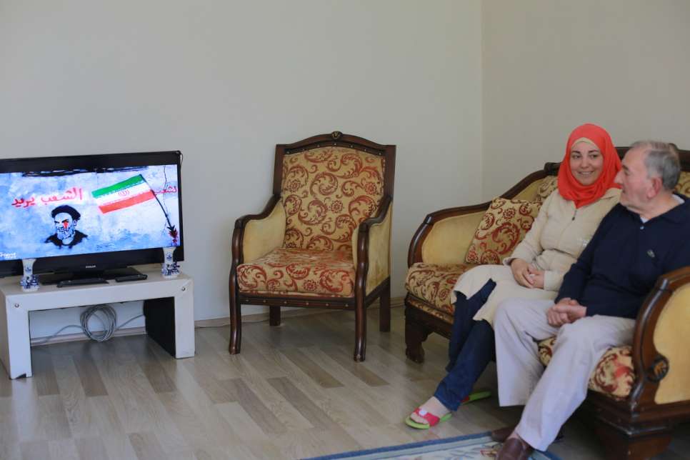 Darie keeps her father, Mahmud, 74, company as he watches Syrian news on television. 