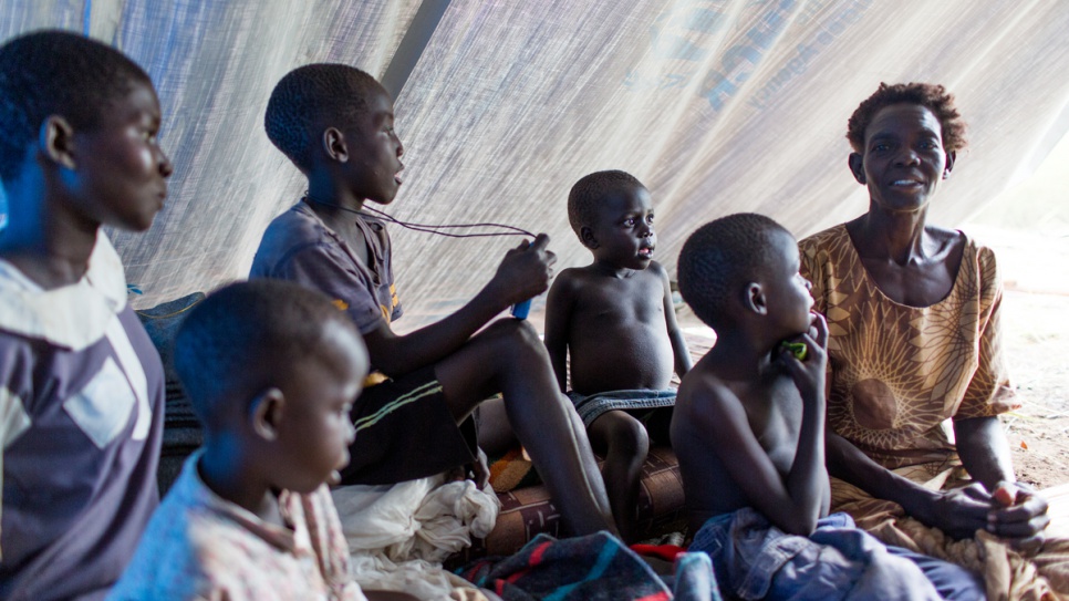 Esther Ojabajon and her family take cover in their temporary shelter during a thunderstorm.