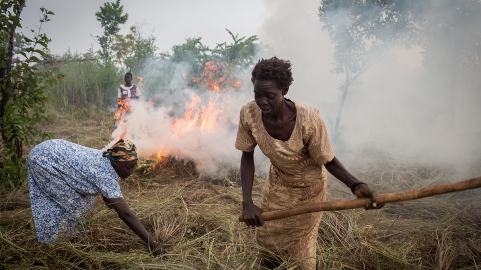 South Sudanese refugee Esther Ojabajon uses fire to clear her newly assigned plot of land in northern Uganda, where she will live with her family.