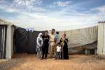 A family of refugees from Syria pose beside a shelter at Azraq camp in...