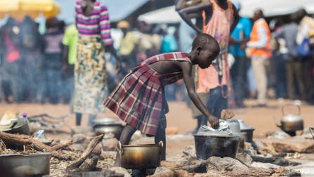 A young refugee from South Sudan cooks food at the reception centre in the newly established Pagarinya 2 camp in Adjumani District, in northern Uganda.  © UNHCR/Will Swanson