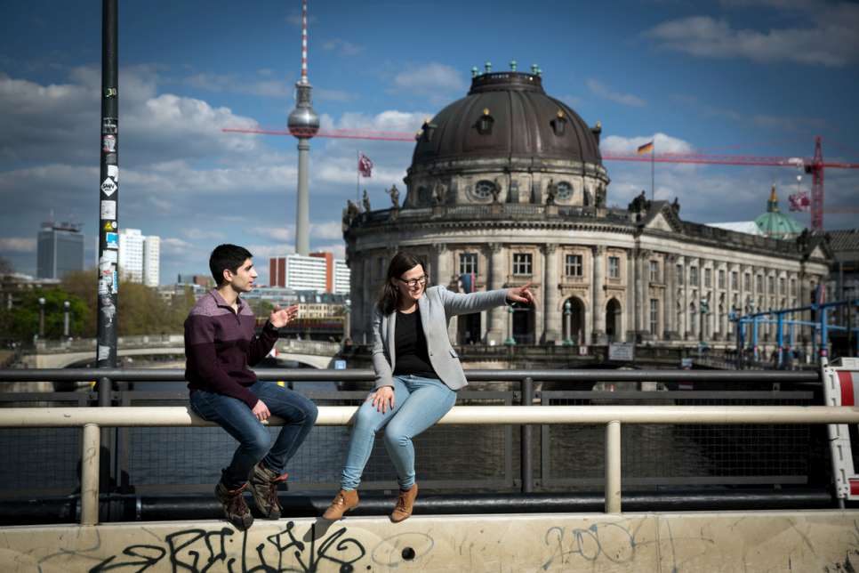 Fahed and Anne-Marie sit together in front of Berlin's Bode Museum, chatting in the sunshine.