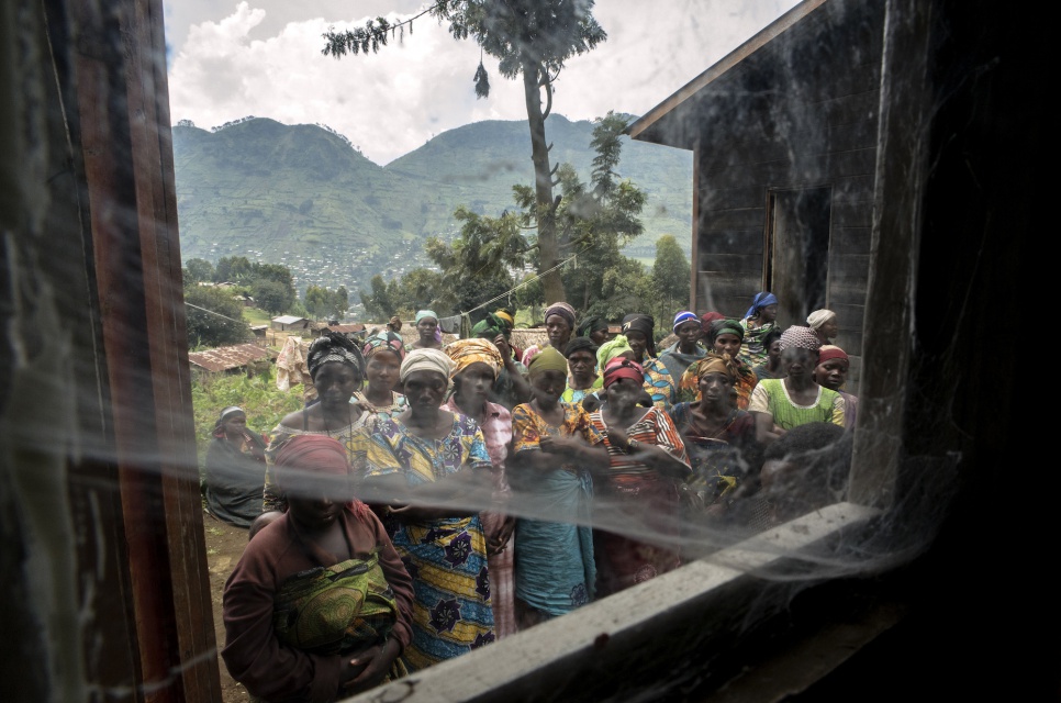 Congolese women, including IDPs and local residents, gather outside the health center in Kitsule, North Kivu. The center provides family planning and STD testing.