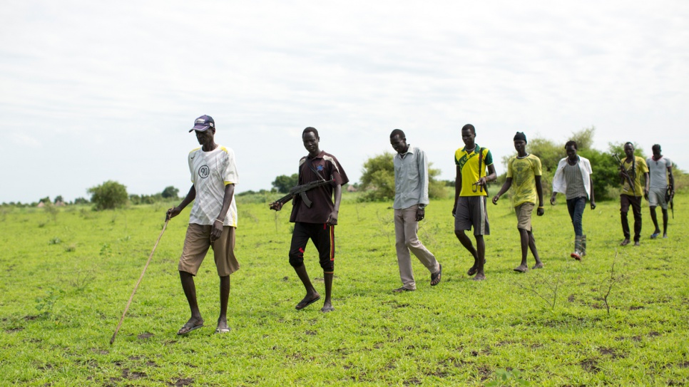 Armed youths escort Gatluak Ruei Kon to his land in Old Akobo, in South Sudan's Jonglei State. "Coming here by yourself is not safe," he says. "But I want to come back here and re-establish my farm."