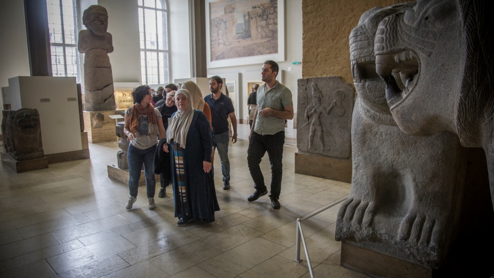 Museum guide Kefah Ali Deeb, 34, leads a group which includes fellow Syrian refugees through Berlin's Ancient Near East of Museum, housed in the Pergamon complex.