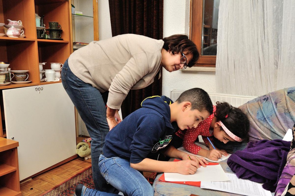 Thuraya and Bashar work on school projects with help from retired local teacher, Waltraud Hamm.