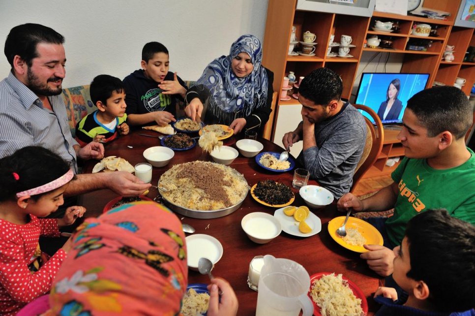 Izdihar and Ameen enjoy a family meal in their new home.