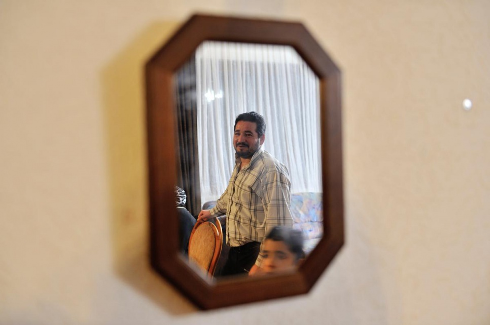 Ameen in the living room of his new home. After a long journey from Syria, he and his family are safe at last in Austria.