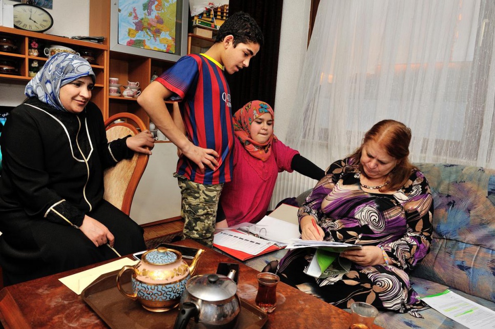 Maria Simlinger helps Muhammed, 15, and Samira, 13, with school work.