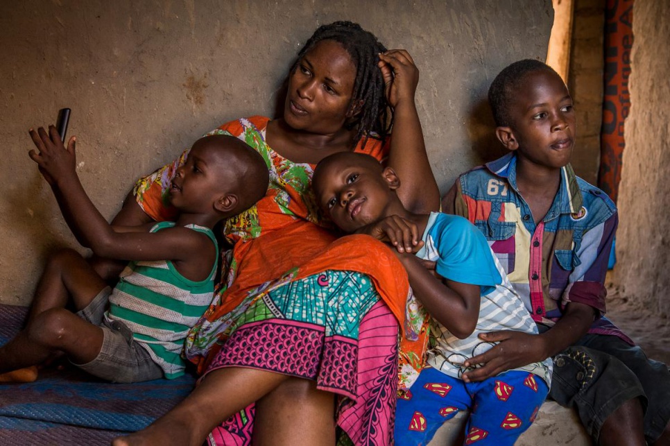 Burundian refugee Nbela, 30, sits with her sons, who range in age from four and 12. Together with her sister Odette, she runs a restaurant in Kashojwa.