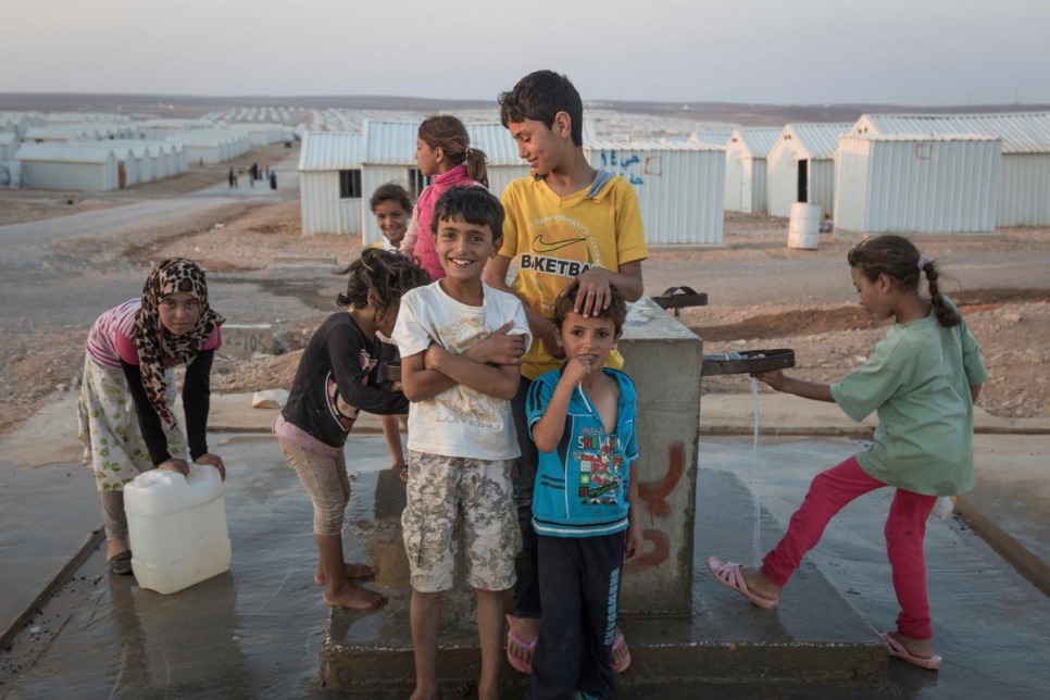 Syrian children getting water from a pump in Azraq camp.
