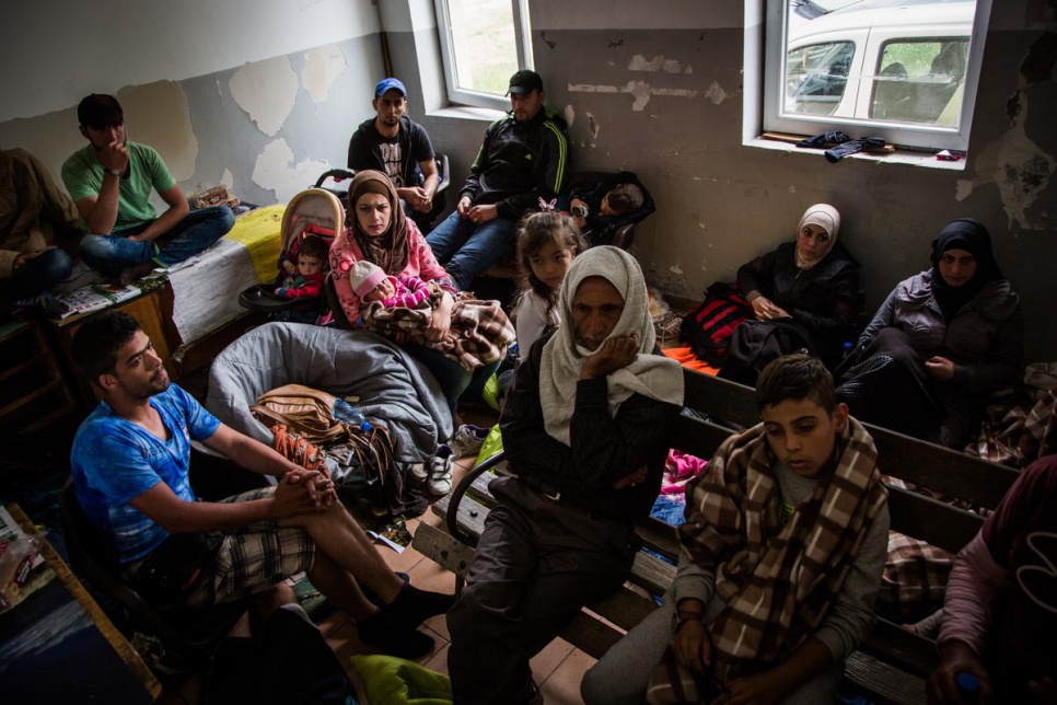 Several refugees, part of a group of about 400, shelter in a train station in Slanishte, in fYROM, after spending the previous day walking in the rain.