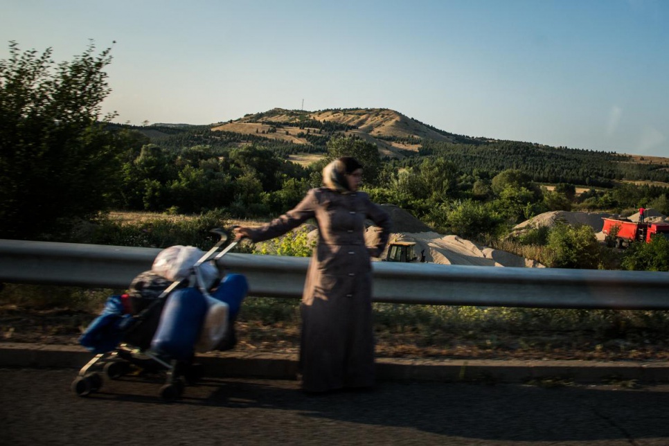 A Syrian refugee pushes a pram along the highway near Veles, in The former Yugoslav Republic of Macedonia.