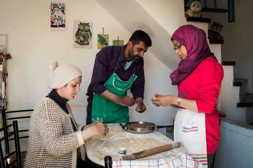 Tarek and his wife, Kinda, prepare dinner in the bungalow they share with their two children and another family.