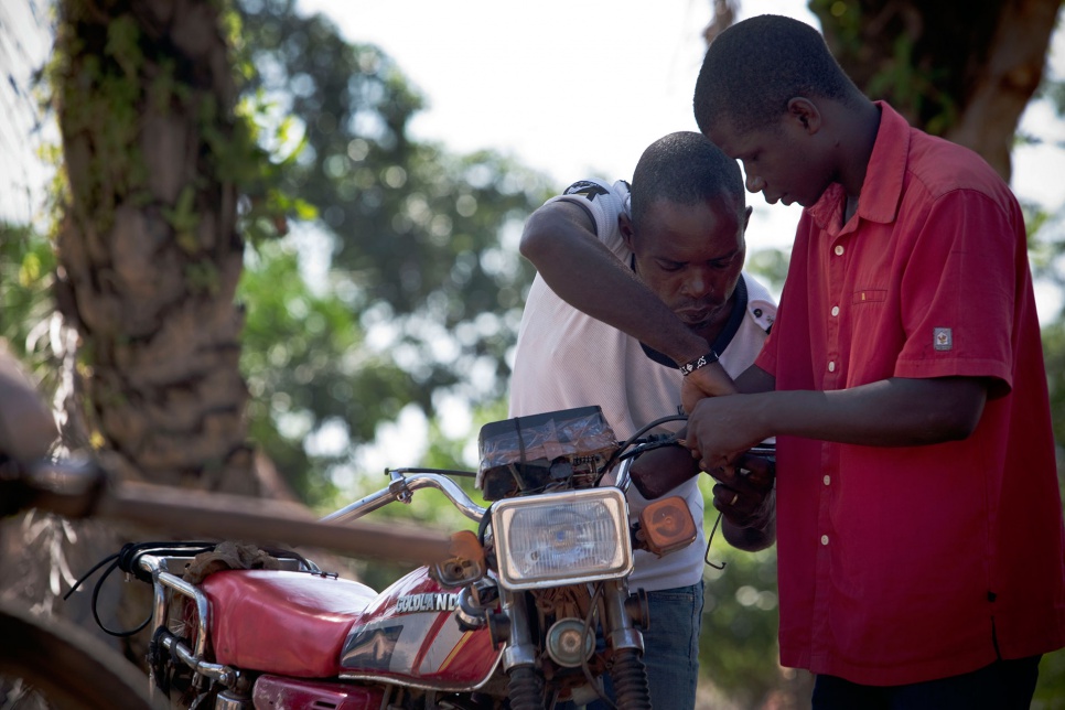 Innocent and a friend move the clutch from the right handlebar to the left, allowing him to drive and change gears with his left hand.