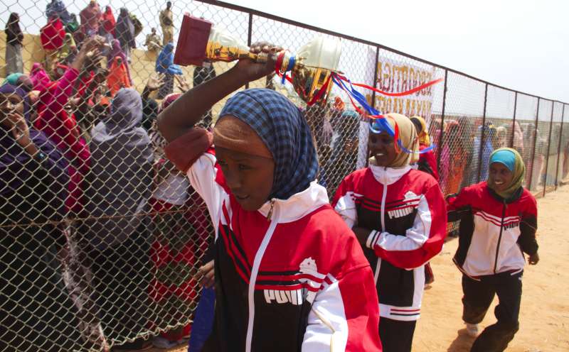 Pour l'équipe féminine de basket-ball qui vient de remporter le trophée, c'est le moment de le brandir devant ses supporters enthousiastes. La scène se déroule au centre de formation que « maman Hawa » a créé à Galkayo, en Somalie. 