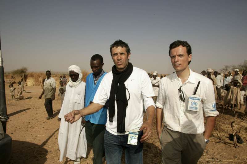 Un chargé de programmes de l'UNHCR explique à Julien Clerc comment les réfugiés soudanais du Darfour sont pris en charge à leur arrivée dans le camp provisoire de Mahamata, dans l'est du Tchad, mars 2004. 