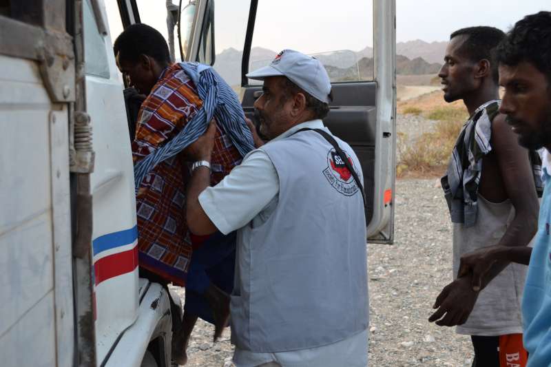 SHS staff help people into a truck that will take them to the Mayfa'a Hadjar Transit Centre.