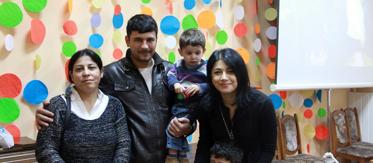 UNHCR Goodwill Ambassador Iskui Abalyan mets a family of resettled refugees in Gomel, Belarus in April 2016. During the mission, she visited the Temporary Accommodation Centre (TAC) to meet refugees from different countries (Ukraine, Syria, Georgia). This photo was taken with a Syrian family at the TAC. They were resettled under the first and the only joint resettlement project of UNHCR and the Ministry of Internal Affairs of Belarus. The family was resettled from Syria to Gomel in February 2015. 
