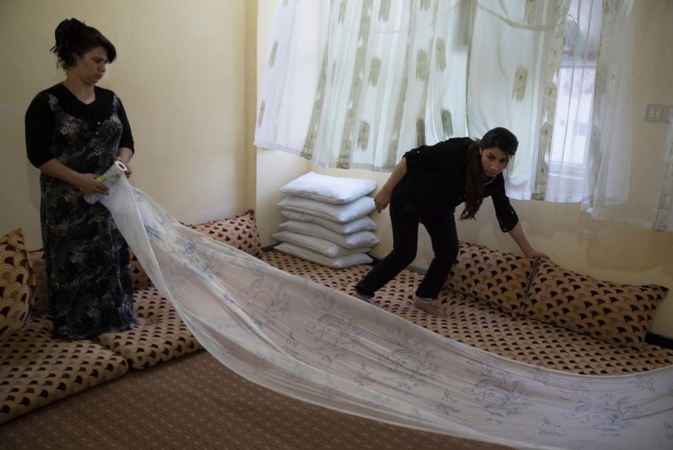 Syrian refugees Shadiya (right) helps her sister Shukriya set the floor for a Ramadan iftar in Dohuk, KRI.