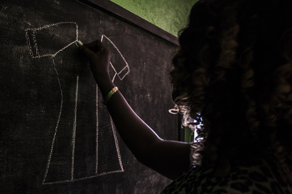 Liberia. Irene draws a dress for her tailoring lesson