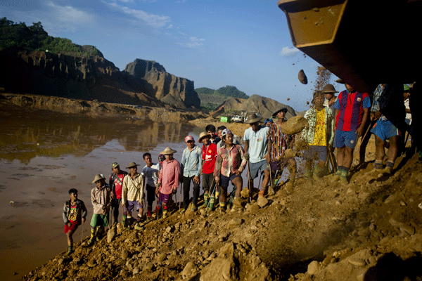Freelance miners dig for raw jade stones in piles of waste rubble dumped by mechanical diggers next to a jade mine in Hpakant, northern Myanmar's Kachin State, Oct. 4, 2015.