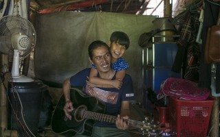 La Htaw Zau Pan plays the guitar with his daughter