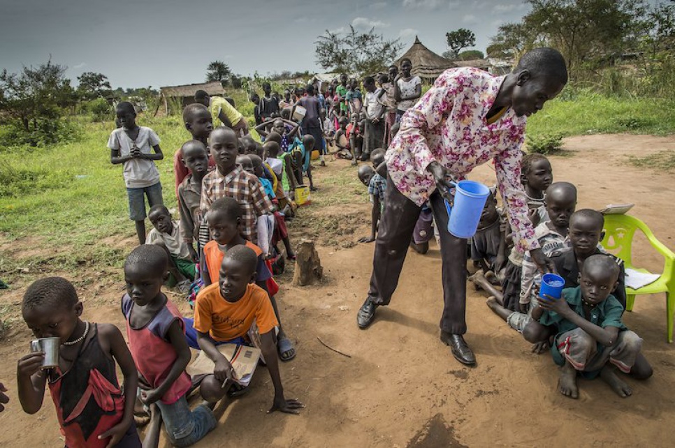 Alaak distributes water to his students during a break from class at Uganda's Nyumanzi refugee settlement.