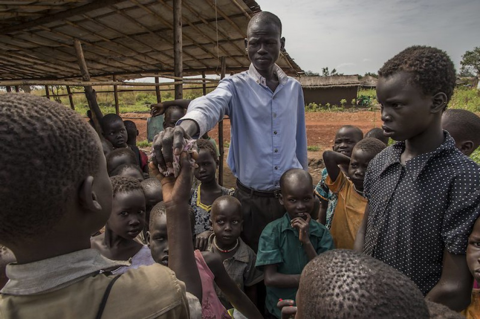 Alaak's cousin John, who volunteers as a teacher at the school, plays peacekeeper during a disagreement between two refugee teenagers over the ownership of a makeshift football.