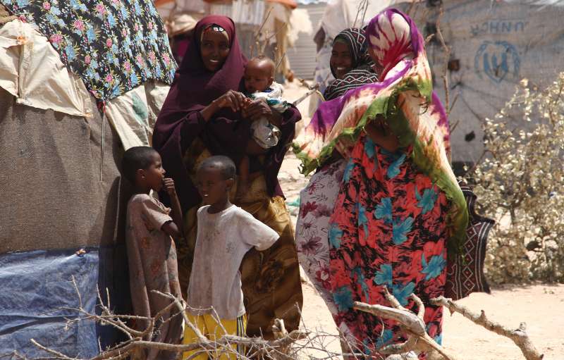 IDP women and children gather outside their makeshift homes at the Halabokhad settlement in Galkayo. 