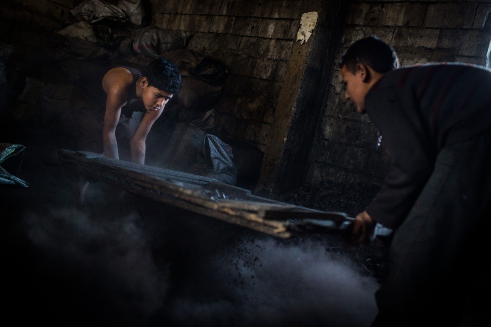 Anas, 12, and Abdullah, 15, sieve charcoal at a shop in Bebnine, Lebanon. "I miss school," says Anas, a refugee from Homs, Syria. "We used to have fun."