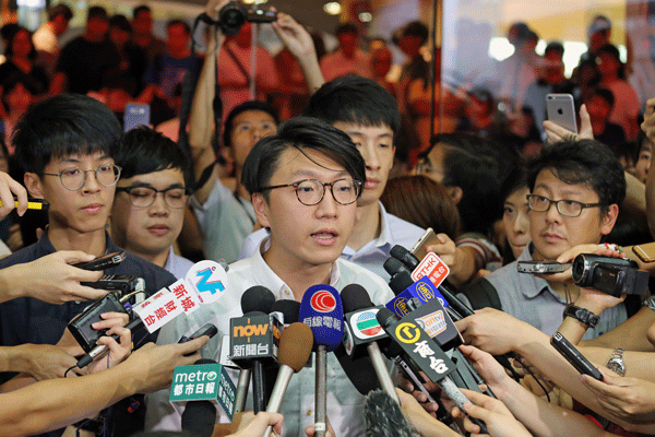 Edward Leung (C) of the localist group Hong Kong Indigenous speaks to reporters after the Electoral Affairs Commission disqualified him from running as a candidate in the Legislative Council election in Hong Kong, Aug. 2, 2016.