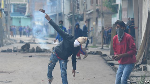 India - A Kashmiri protestor throws a stone towards Indian government forces during clashes in Srinagar on August 29, 2016