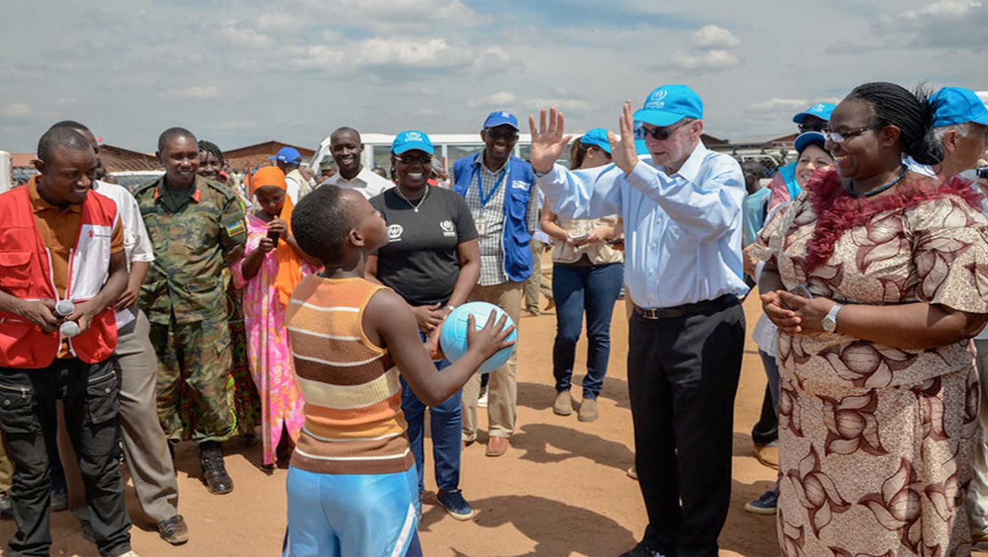 Hon. Minister of MIDIMAR, Seraphine Mukantabana and Dr. Jacques Rogge, UN Special Evoye for Youth Refugees and Sports offer a ball to the captain of female volleyball team in Mahama refugee camp [Photo/ IOC Shaban Masengesho]