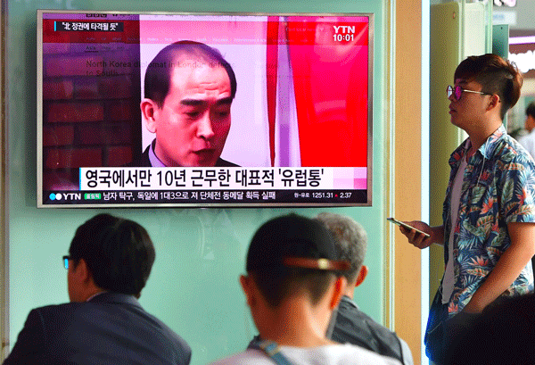 People watch a television news broadcast showing file footage of Thae Yong Ho, a top North Korean diplomat who recently defected to South Korea, at a railway station in Seoul, Aug. 18, 2016.