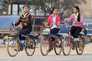 Girls ride their bikes to school in Luang Prabang, Oct. 10, 2010.