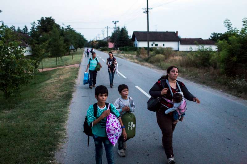 In Horgos, Serbia, a mother and her three children walk along a road towards a railway line that will lead them to Hungary.