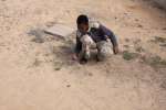 صبي يلعب بالدحل (الجلل) في الأكاديمية البحرية بالقرب من طرابلس. أُجبر أهل تاورغا على مغادرة منازلهم بسبب دعمهم المزعوم لمعمر القذافي.