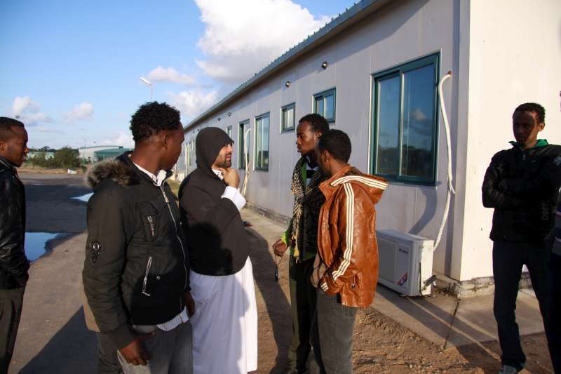 موظف تابع للمفوضية يتحدث مع مجموعة من الصوماليين في موقع السكك الحديدية عن الظروف والاحتياجات.