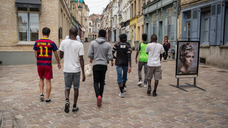 A group of unaccompanied children from Afghanistan, Chad and Sudan walk through the streets of Saint-Omer on their way to a gardening lesson.