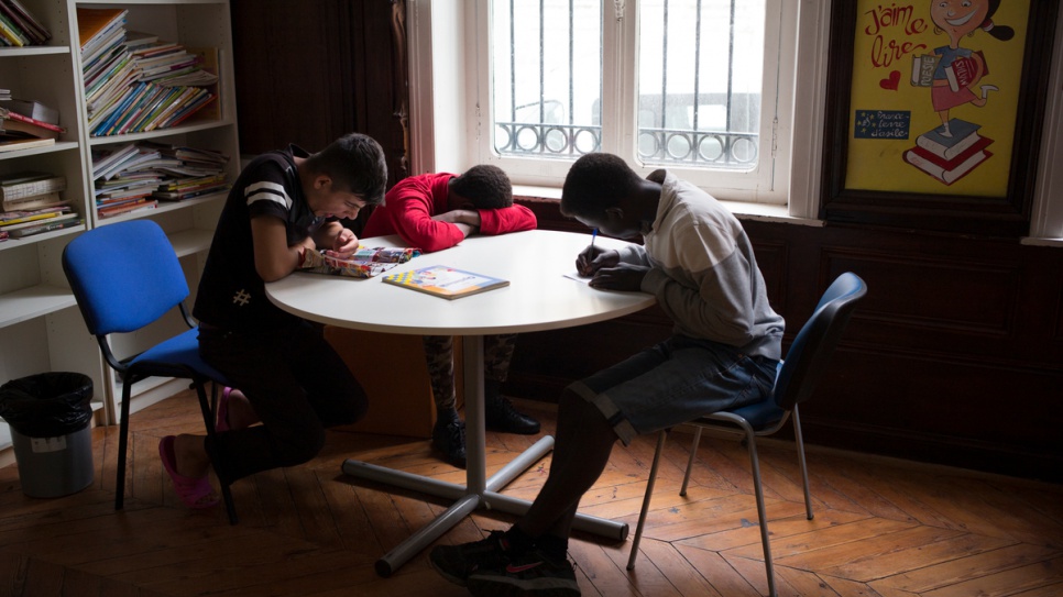 Des enfants non accompagnés originaires du Soudan et de l'Afghanistan lisent, écrivent ou se reposent dans un foyer à St-Omer. 