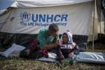 Mahmoud, a Syrian refugee from Aleppo, plays with his son Jawad, 4, in front of their tent in Hungary. 