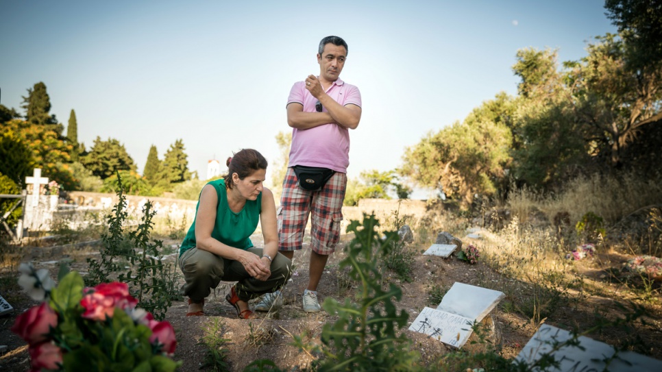 Efi Latsoudi, along with friend and interpreter Mohammadi, takes a moment to reflect at a cemetery where many refugees who drowned in the Aegean Sea now lie.