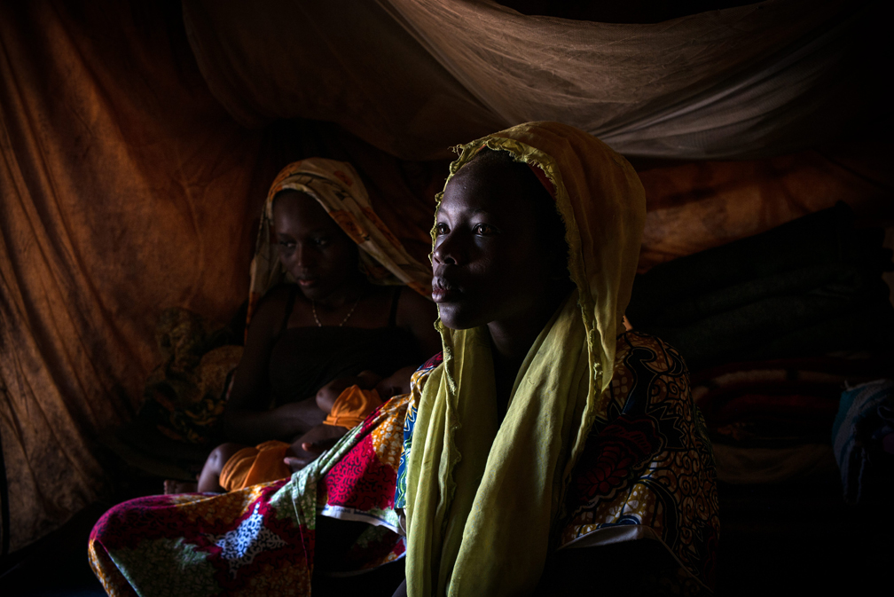 Sadia, 14, sits with relatives in her father’s tent at the refugee site in Gado, Cameroon. A few days earlier, she was beaten by her husband. UNHCR / Olivier Laban-Mattei