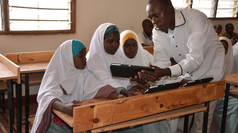 Michael Mutinda, a teacher in one of the primary schools at Dadaab refugee camp in Kenya, shows his pupils how a tablet computer works, in this 2014 file photo.