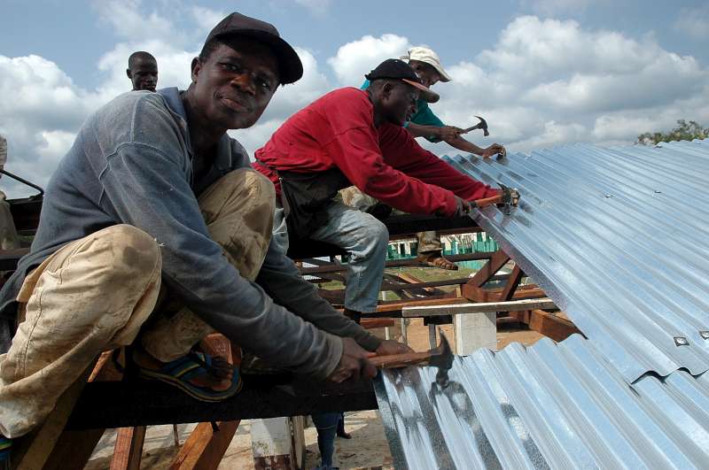 Through a special community empowerment project, these displaced people are building a school, and a roof for the market place in Gbarlatuah Town, Bong County, Liberia. 