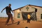 Teenager Conwell plays football at the Boy's Shelter in Nancefield, Musina, South Africa. The shelter houses more than 200 boys aged up to 16. Most of the boys crossed the border unaccompanied. They are given food, shelter and lessons. 